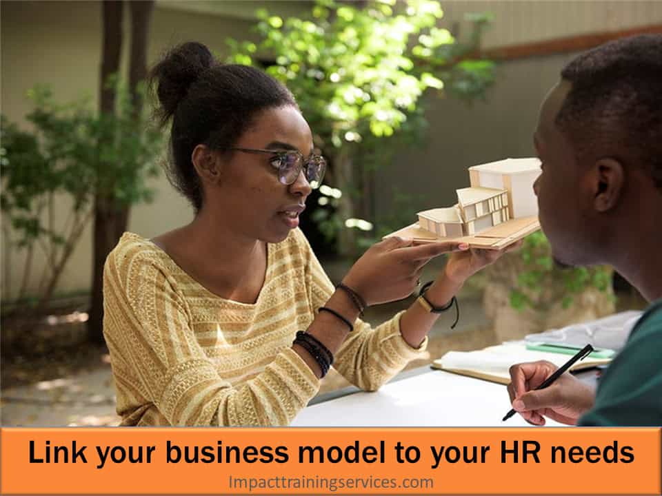 Small businesswoman holding model of her business which should be linked to her HR needs when hiring right