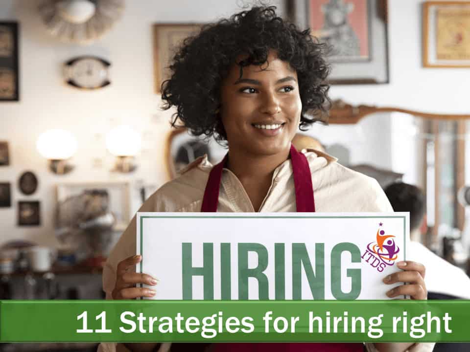 Smiling young female employee holding up hiring sign showing the business is hiring right