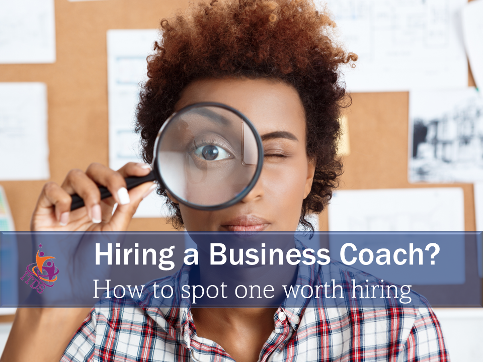 woman with a magnifying glass symbolising how to spot a business worth hiring